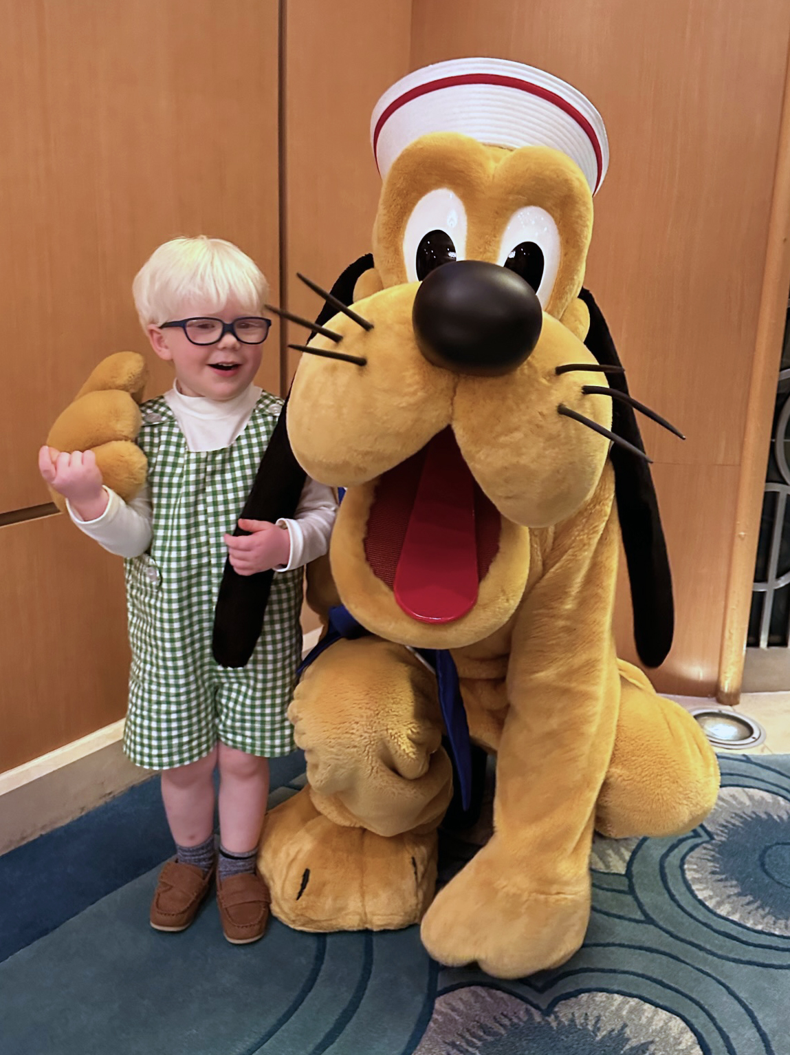AJ standing with Pluto dressed in a sailor outfit