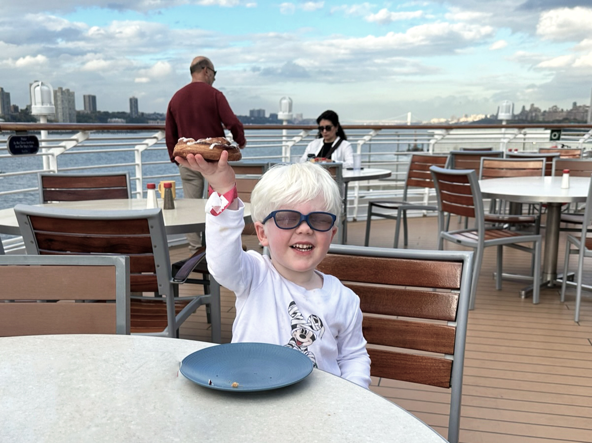 AJ holding up a cinnamon roll from the Cove Cafe