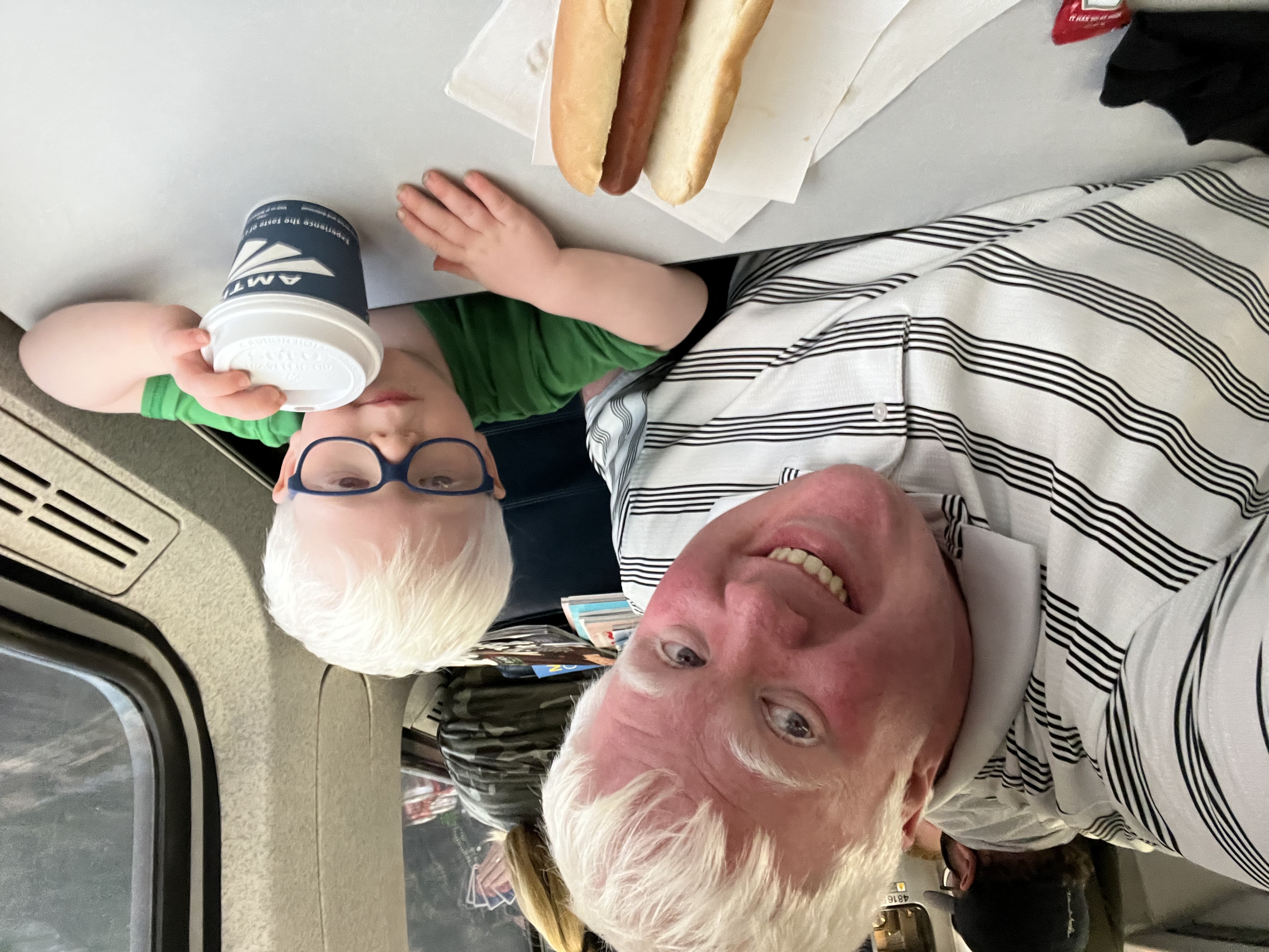 A picture of Andrew and AJ sitting at a table in the cafe care of amtrak with a hot-dog